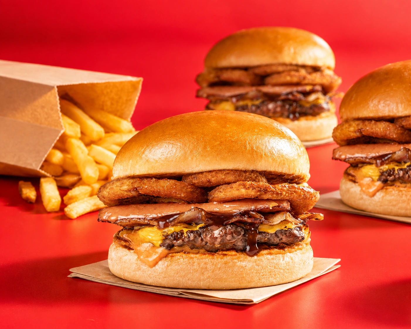 Beast Burgers with crispy onion rings, melted cheese, bacon and golden fries